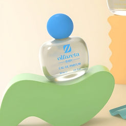 Flacon transparent Olfazeta by Chogan Baby N°45, bouchon bleu, posé sur une vague verte pastel